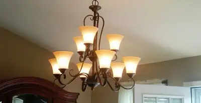 Classic ceiling chandelier installation with warm lighting in Overland Park, KS