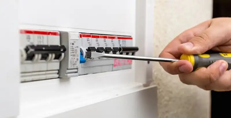 electrical panel upgrade service showing technician adjusting circuit breakers during system upgrade in Overland Park, KS