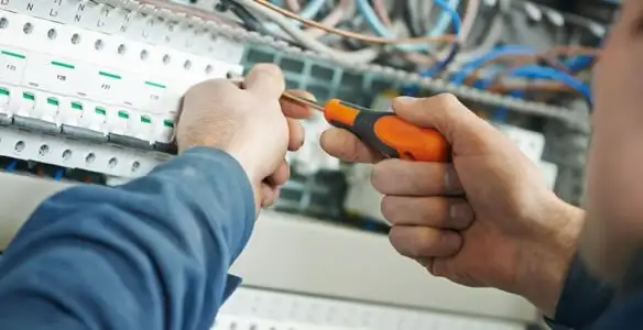 electrical service showing licensed electrician performing electrical panel maintenance and adjustments in Overland Park, KS