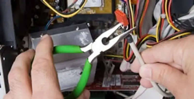 Licensed electrical contractor performing electrical repair with tools in Lenexa, KS