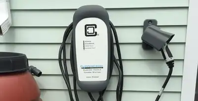 Outdoor electric vehicle charger installation on residential wall in Overland Park, KS